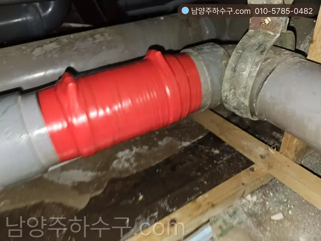 배관 이음부에 붉은 커플링을 체결한 본관 접속부 작업