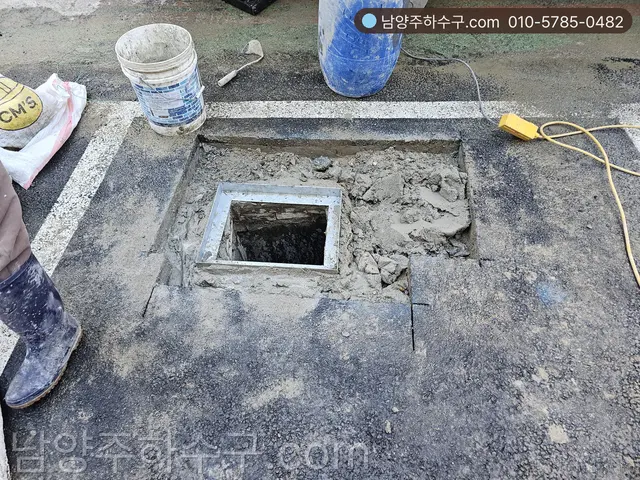 굴착 뒤 채움과 시멘트 마감 중인 점검구