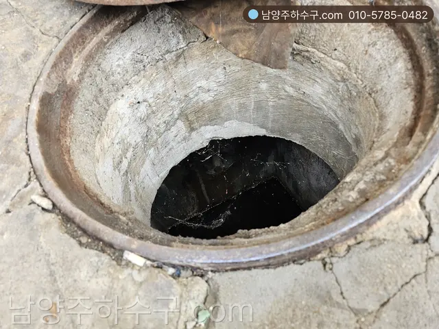 맨홀 뚜껑을 열고 물이 찬 내부와 유입관 높이를 확인하는 모습