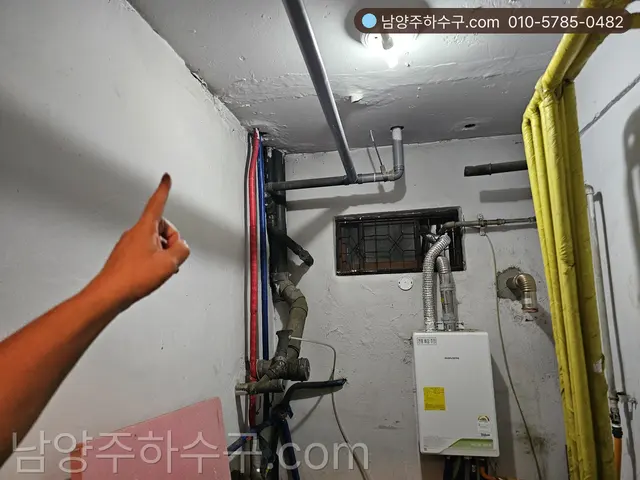 천장 노출 배관을 가리키며 새는 경로를 점검하는 장면